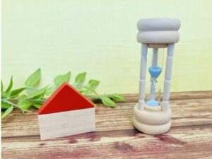 家の模型と砂時計の残り時間