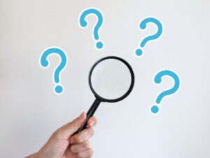 虫眼鏡を持った手とはてなマーク